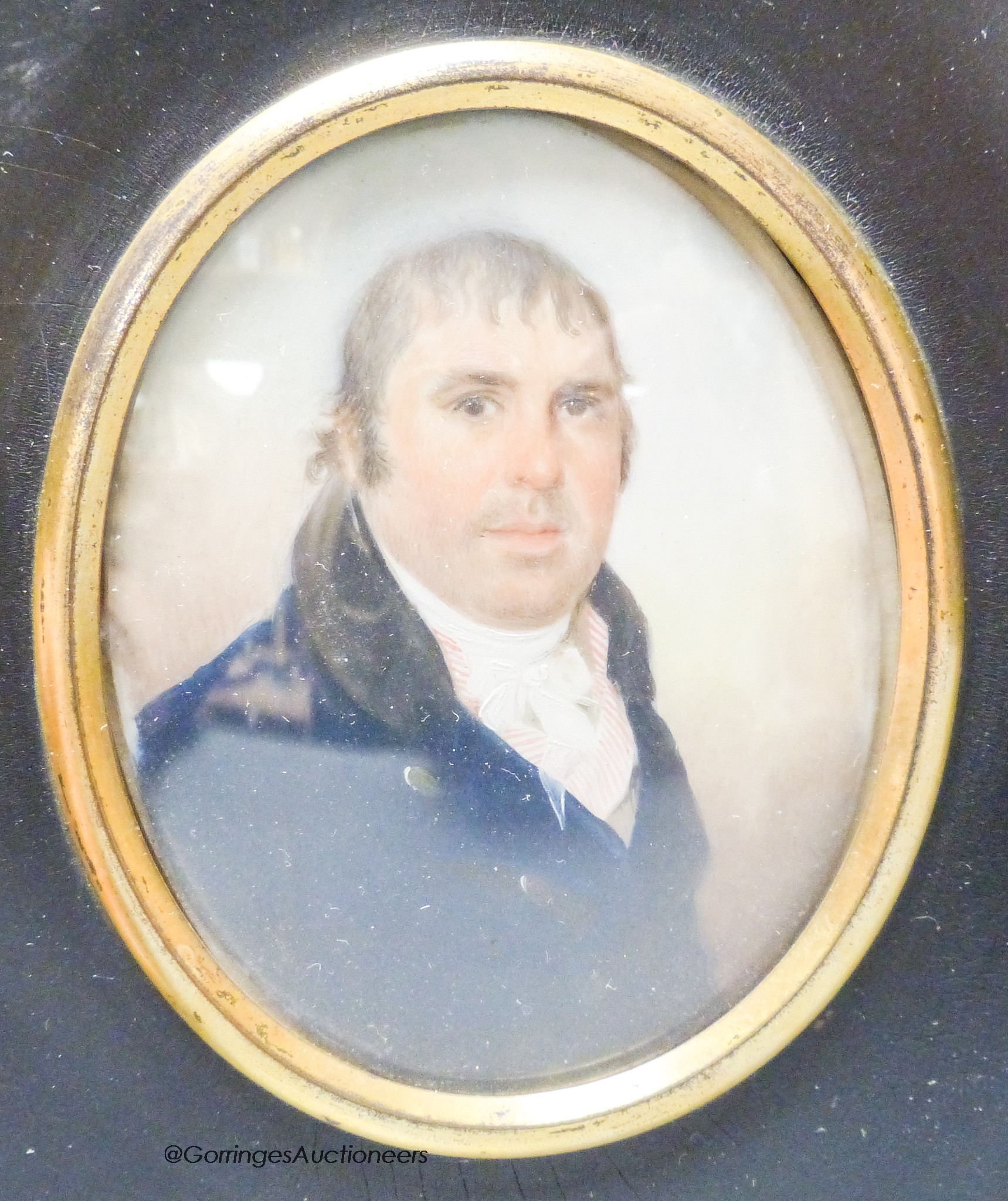 A 19th century portrait miniature, study of a gentleman, in blue tunic with white collar and striped shirt